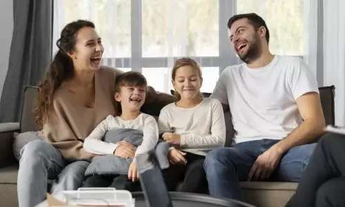 Família tendo um diálogo familiar enquanto está sentada no sofá.